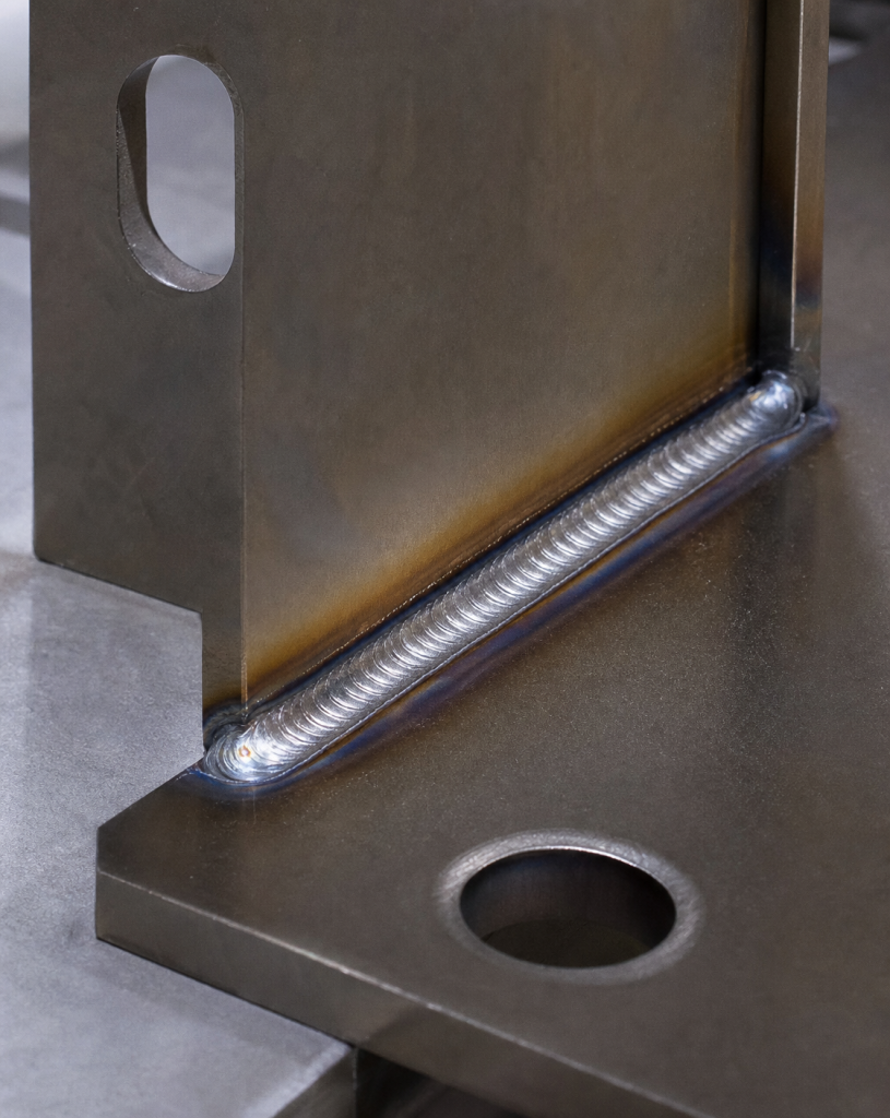 Close-up of a robust robotic MIG weld bead on a thick steel corner joint